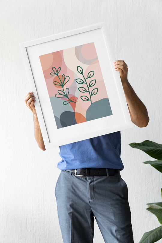 Person holding a framed abstract art print against a white wall