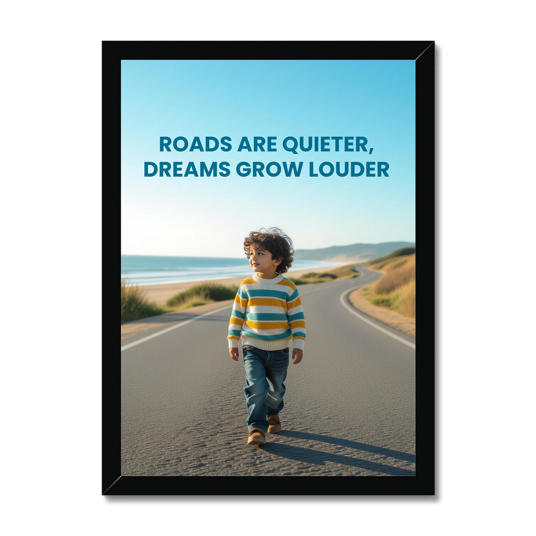 Framed poster with a child walking on a road by the beach and text 'Roads are quieter, dreams grow louder'.