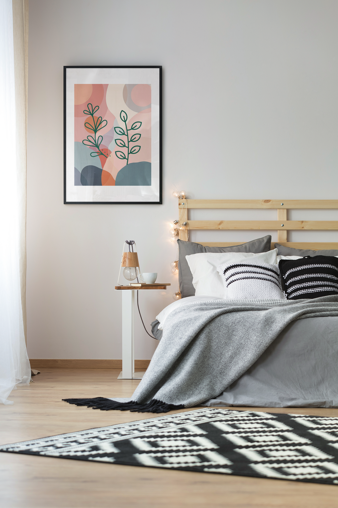 Bedroom with wooden headboard, gray bedding, and abstract art on wall.