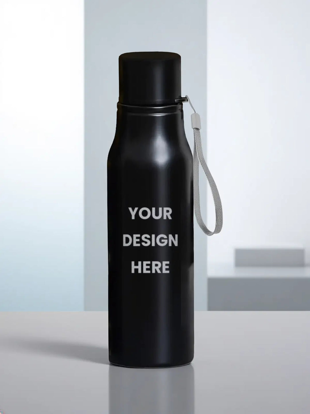 A matte black insulated water bottle with a matching black cap and a white wrist strap, standing on a light gray surface. The bottle has placeholder white text reading &