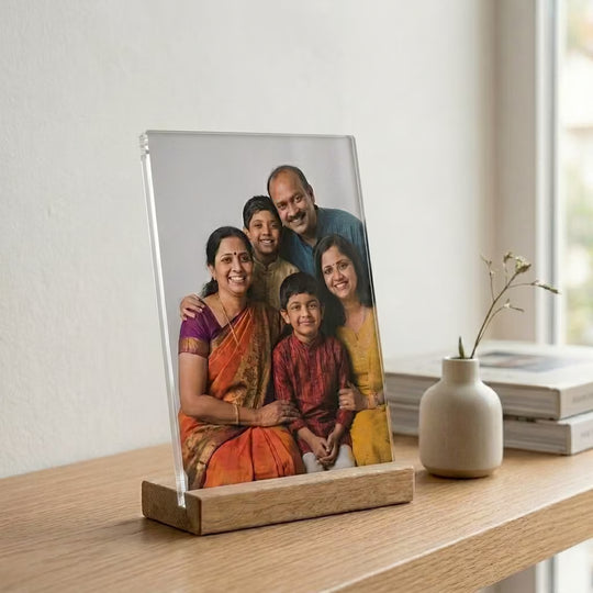 Custom acrylic photo frame with wooden base featuring a family portrait in a minimalist home setting.