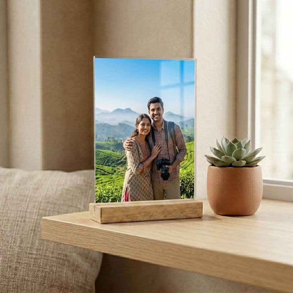 Personalised acrylic photo frame with wooden stand displayed on a modern table in a cozy living room.