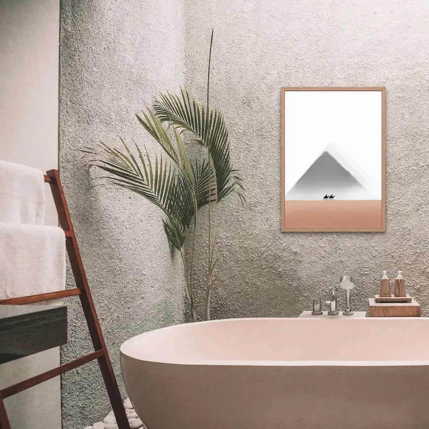 Framed minimalist wall art print by Printlagoon displayed above a modern freestanding bathtub in a luxury bathroom, featuring a serene desert landscape with a mountain, premium wooden frame, and contemporary interior décor. 