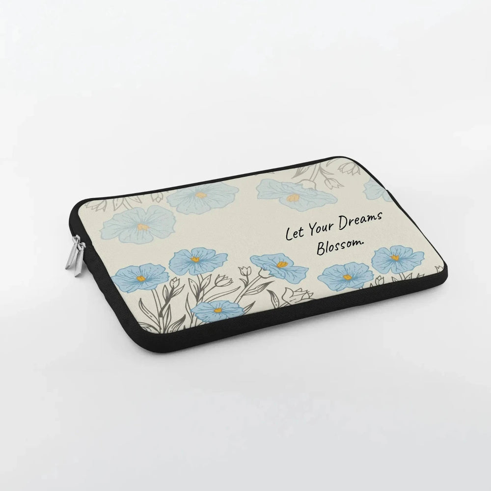 Blue floral laptop sleeve printed with “Let Your Dreams Blossom”